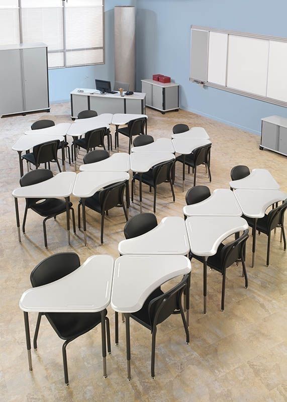 an empty classroom with desks and chairs in the middle, all facing different directions