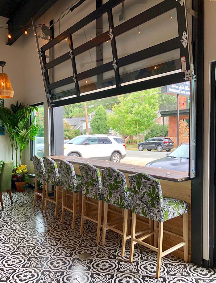 an empty restaurant with tables and chairs in front of a window that looks out onto the street