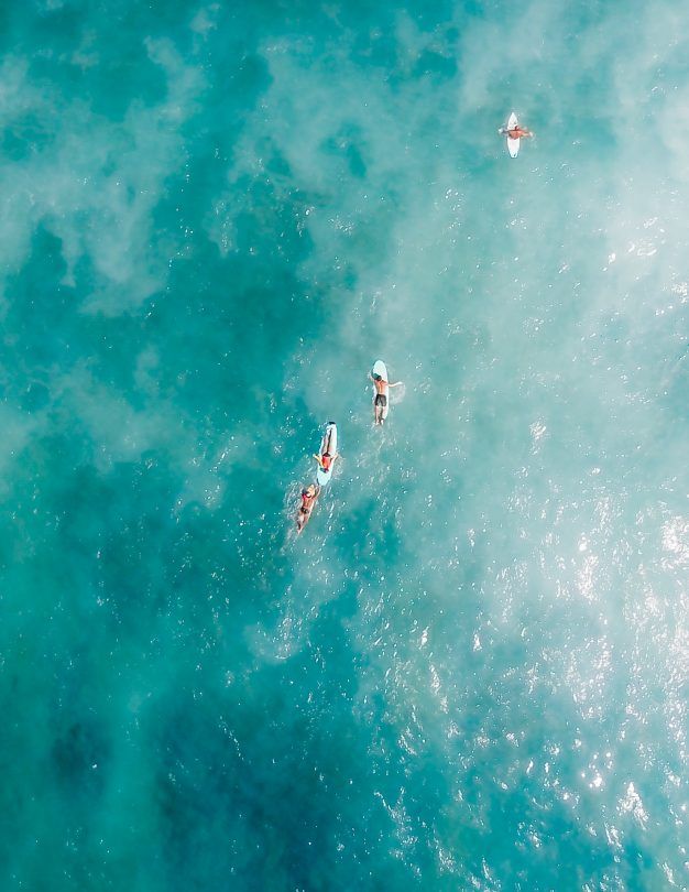 three people on surfboards in the ocean