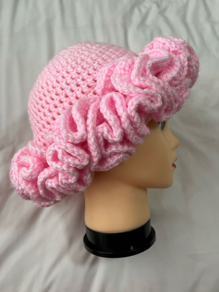 a pink crocheted hat on top of a mannequin head