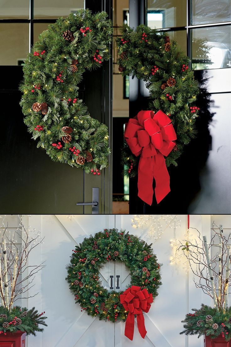 christmas wreaths hanging on the side of a building with red bows and pine cones