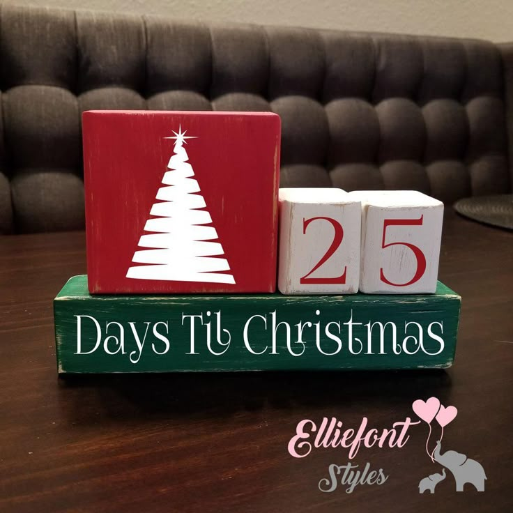 a wooden block with the words 25 days to christmas on it and a small white tree