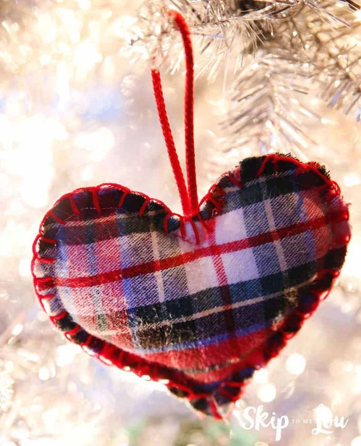 a plaid heart ornament hanging from a christmas tree