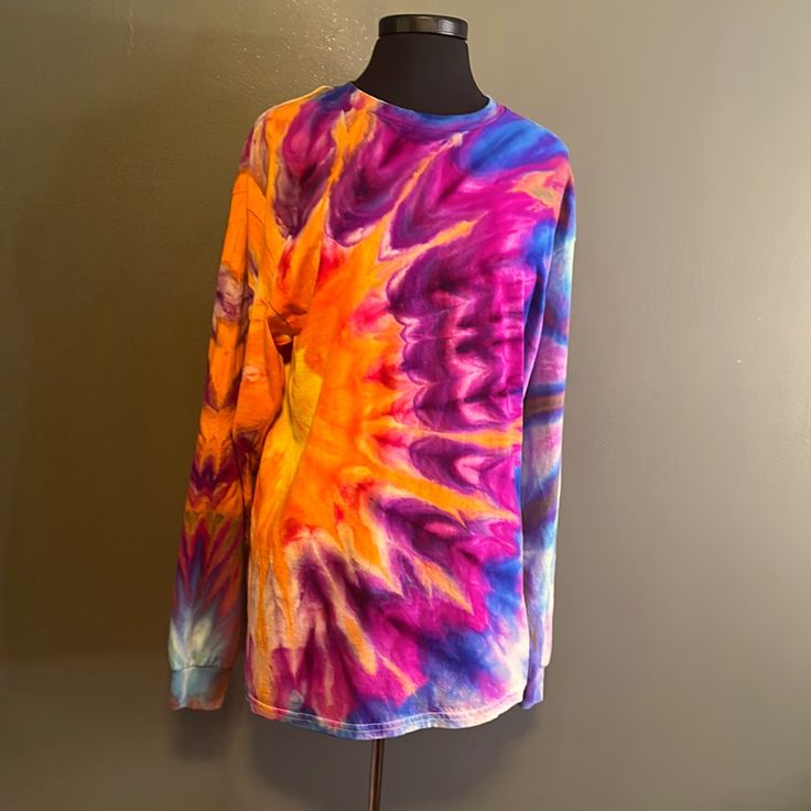 a colorful tie - dyed shirt is displayed on a mannequin