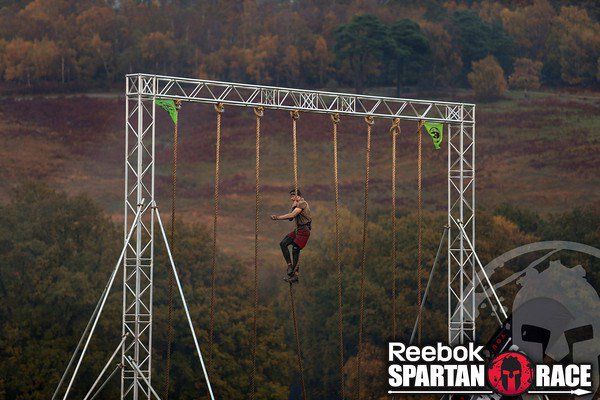 a man is zipping through the air on a rope course with trees in the background