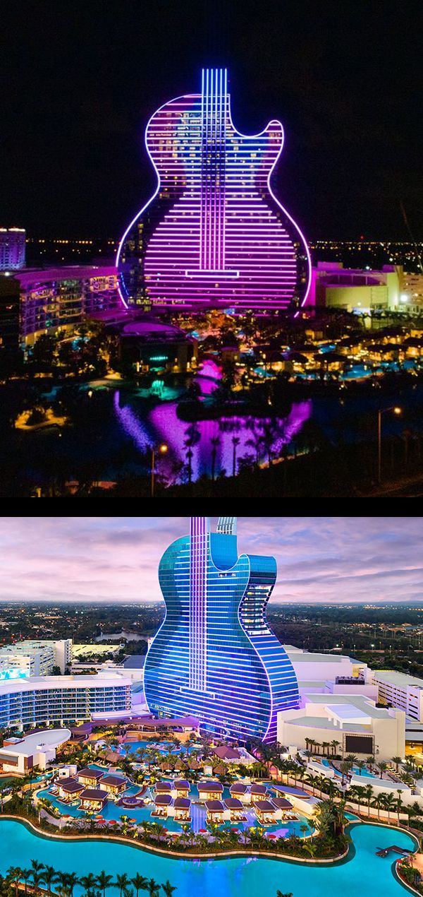 the guitar shaped building is lit up at night and in the middle of the city