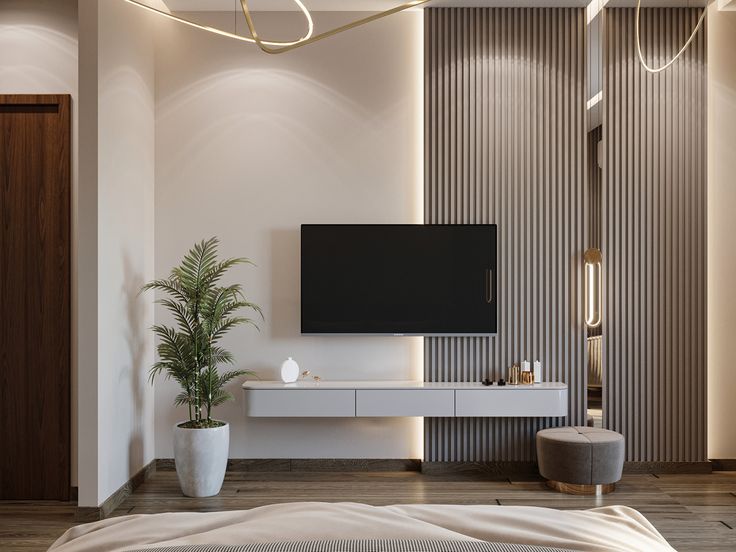 a bedroom with a large flat screen tv mounted on the wall next to a plant