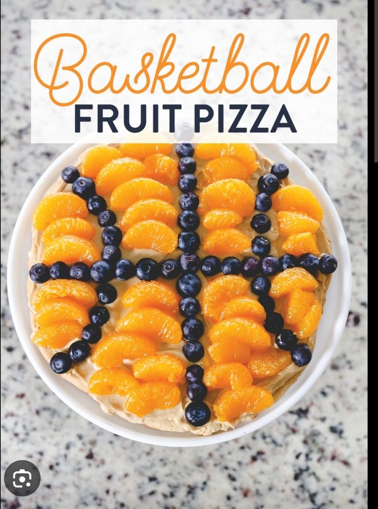 a bowl filled with oranges and blueberries on top of a counter next to the words basketball fruit pizza