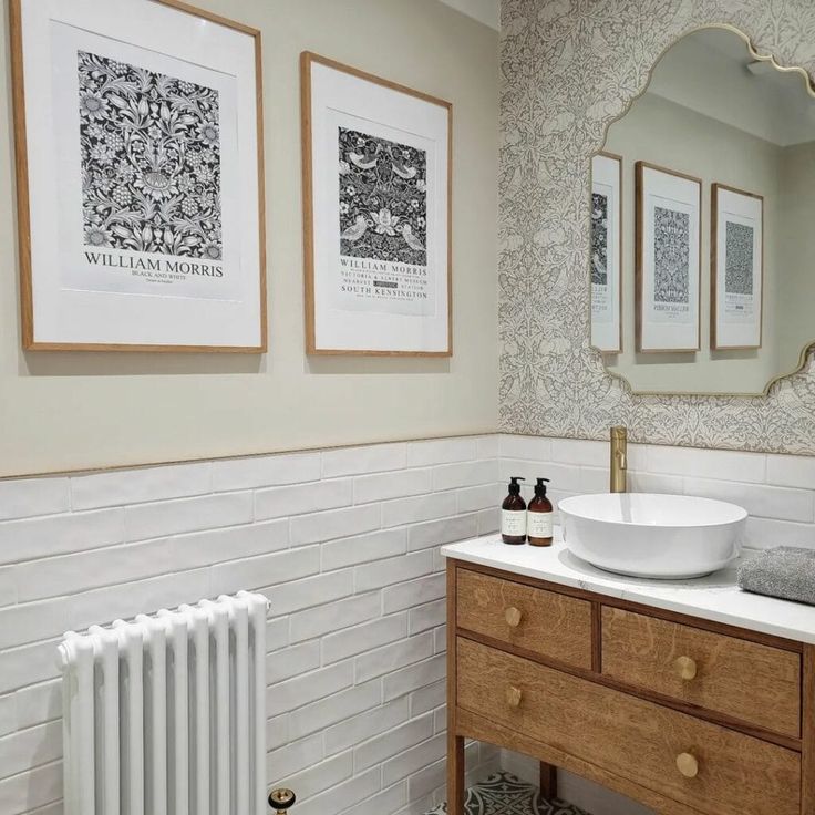 a bathroom with two pictures on the wall and a white sink in front of it