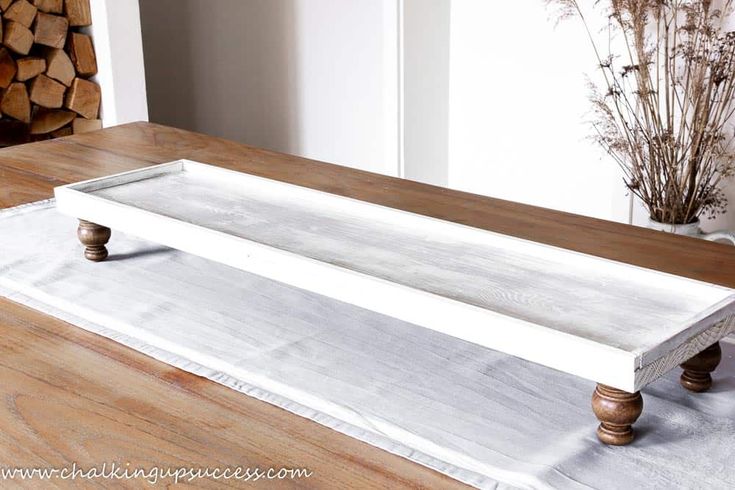 a white tray sitting on top of a wooden table next to a pile of logs