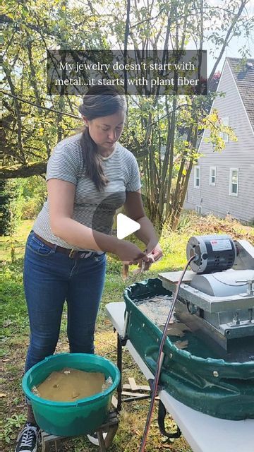 a woman standing next to a green wagon filled with dirt