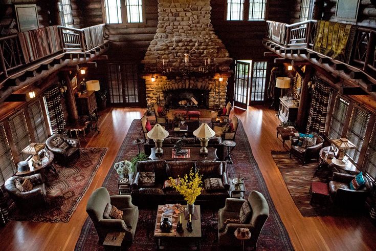 a large living room filled with lots of furniture next to a fire place in a building