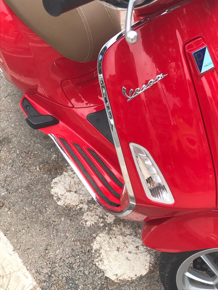 a red scooter is parked on the street