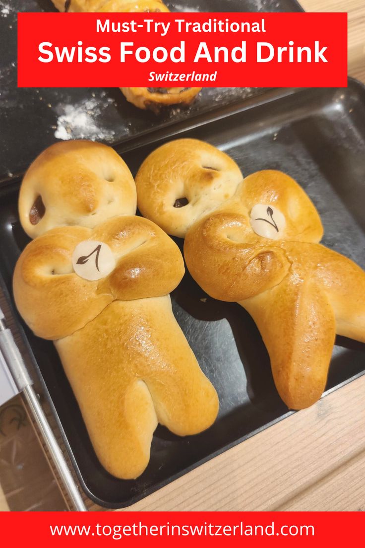 some bread shaped like animals sitting on top of a baking pan with the words must try traditional swiss food and drink