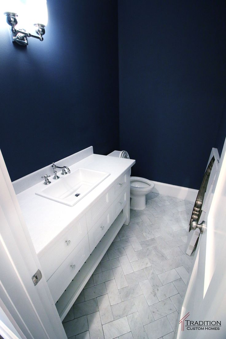 a bathroom with blue walls and white fixtures