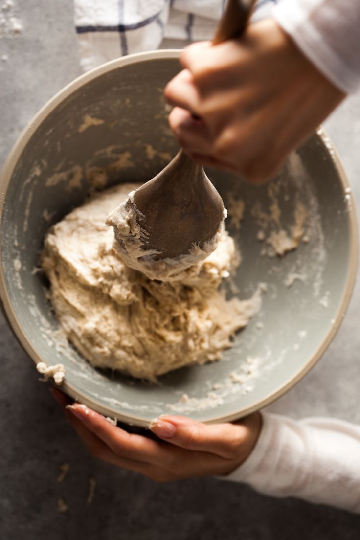 a person mixing food in a bowl with a mixer