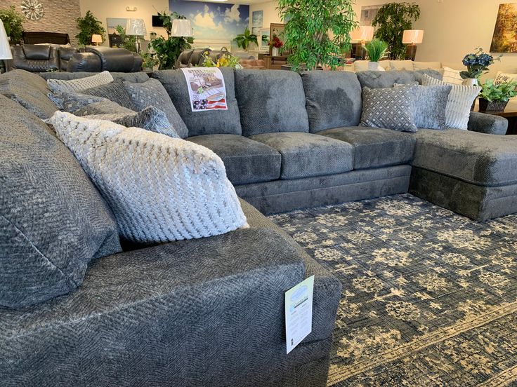 a living room filled with lots of couches and pillows on top of a rug