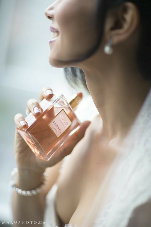 a woman holding a bottle of perfume in her hand