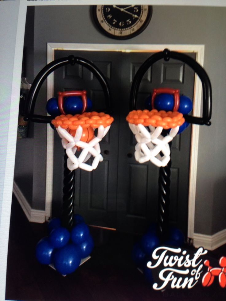 two basketball hoops made out of balloons in front of a door with a clock on the wall