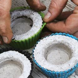 two men are making cupcakes out of paper and plastic cups with their hands