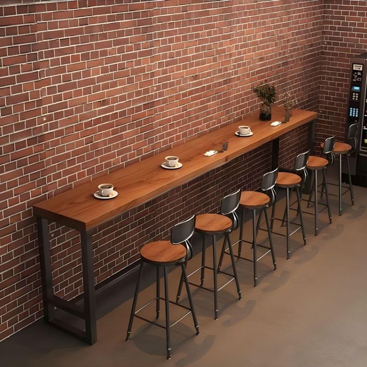 a row of bar stools next to a brick wall with a vending machine