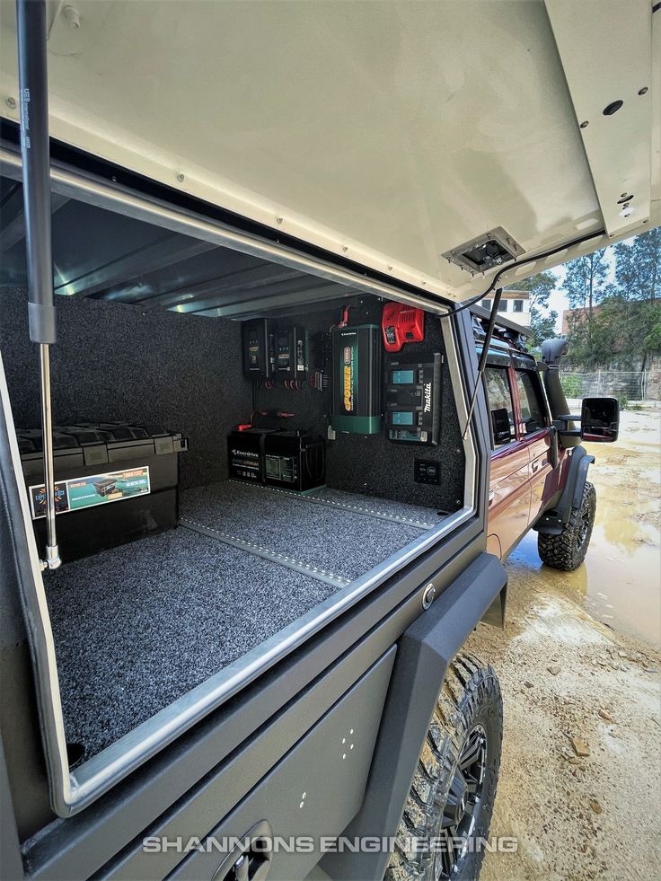 the back end of a truck with its doors open and several electronics in it's compartment