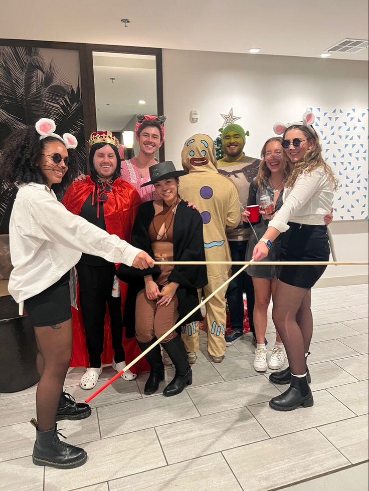 a group of people in costumes posing for a photo with one person holding a rope