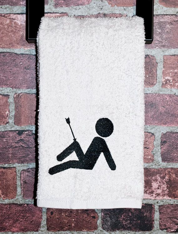 a towel hanging on a brick wall with a silhouette of a person holding a spear