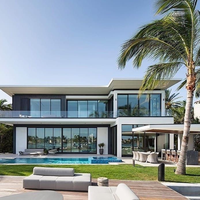 a large modern house with a pool in the backyard