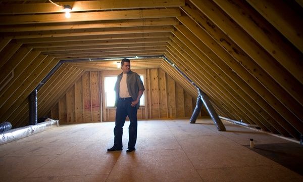 a man standing in the middle of an attic