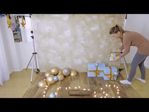 a woman is decorating presents on the floor with candles and lights in front of her