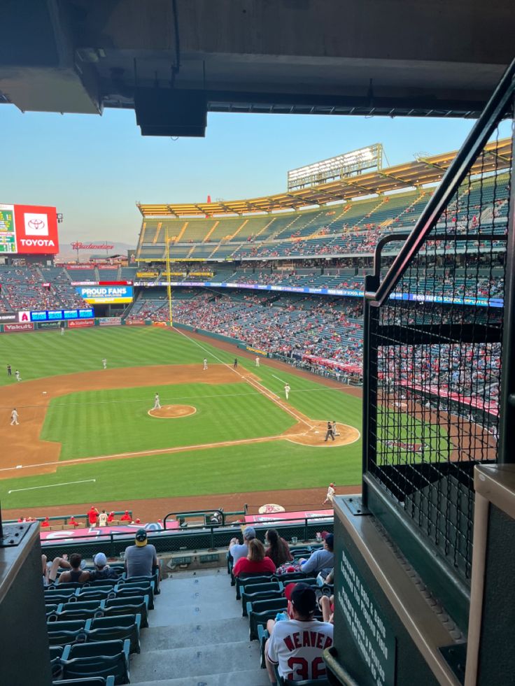 a baseball stadium filled with lots of people sitting on the bleachers watching a game