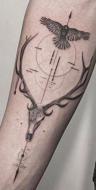 a tattoo on the arm of a man with a deer's head and arrows