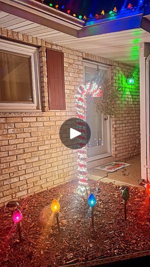 a christmas decoration in front of a house with colorful lights on the outside and inside