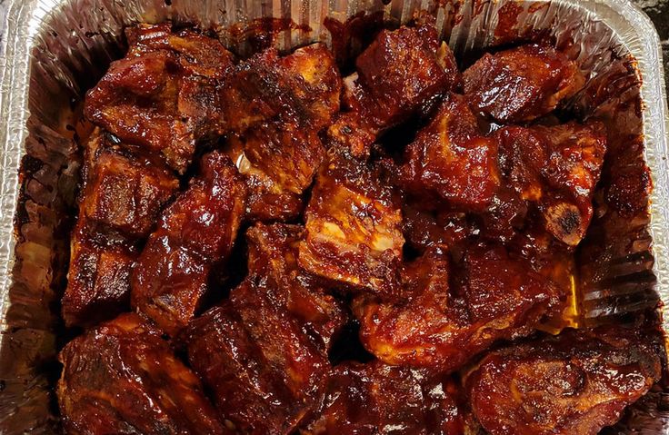 a tin foil container filled with meat on top of a table