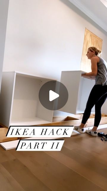 a woman riding a skateboard on top of a wooden floor next to white boxes