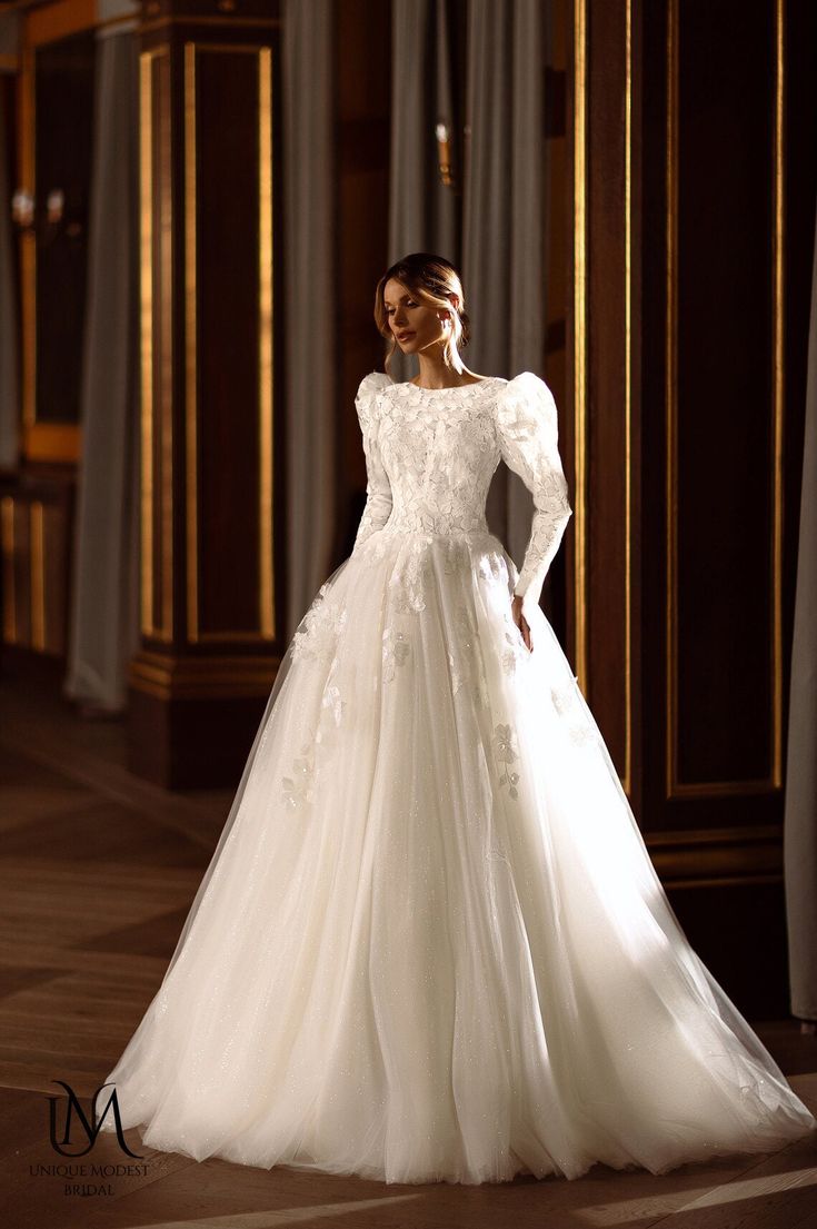 a woman in a white wedding dress standing on a wooden floor