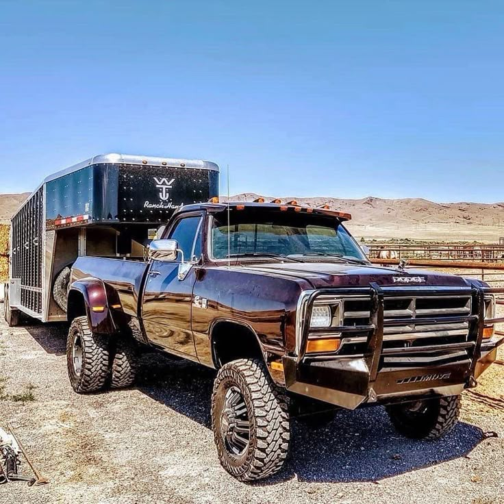 a truck with a trailer attached to it's bed parked in the middle of nowhere