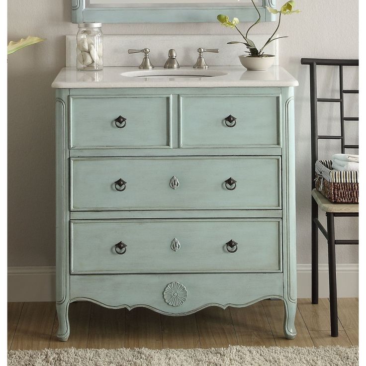 a bathroom vanity with a mirror above it and a vase on the counter next to it