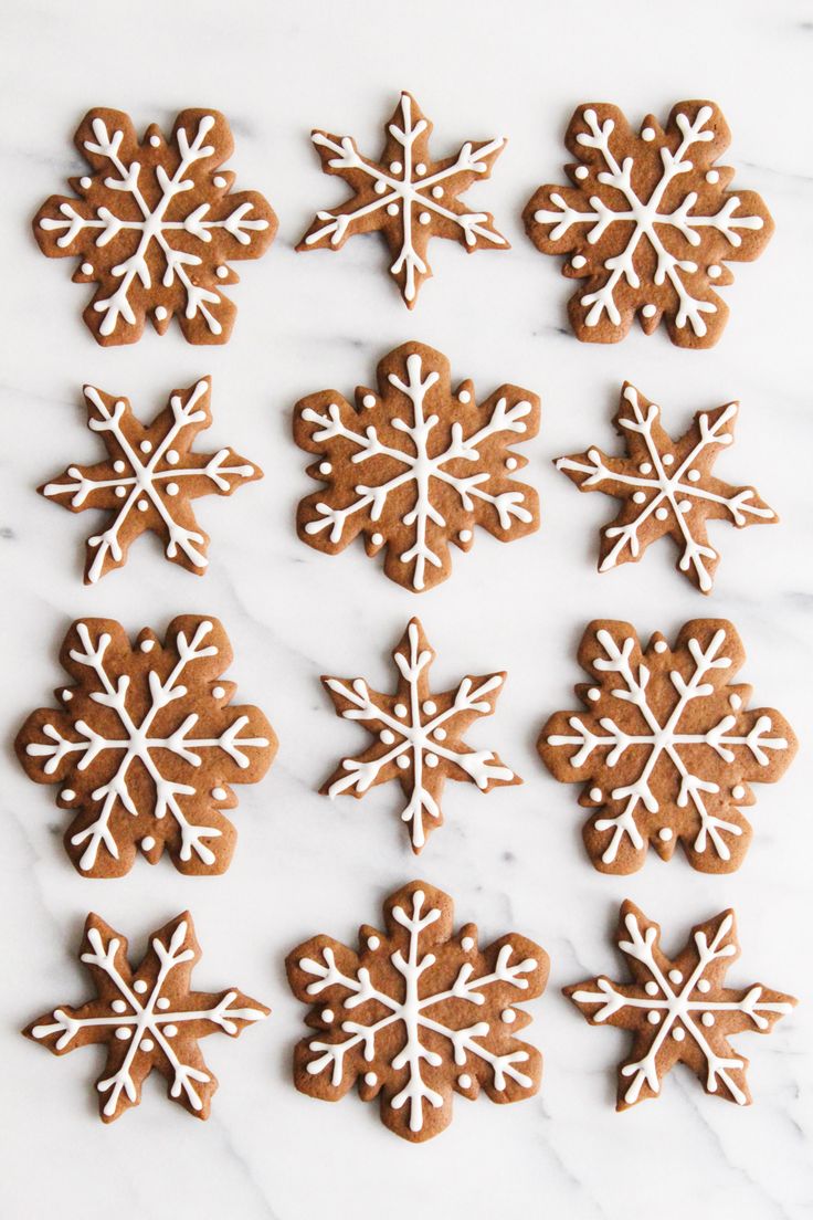 several cookies with white icing and snowflakes on them are arranged in the shape of snowflakes