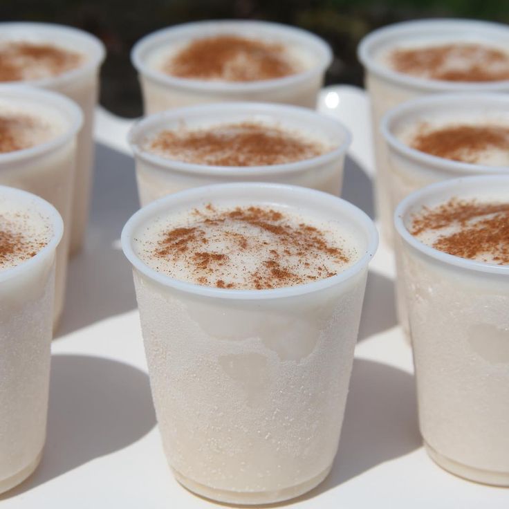 there are many cups with different types of drinks in them on the table and one is filled with cinnamon sprinkles