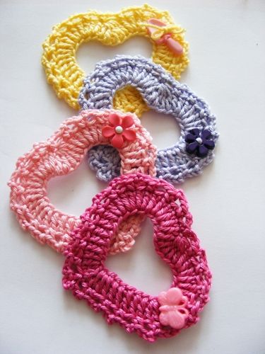 four crocheted hair ties with flowers on each end and one knot in the middle