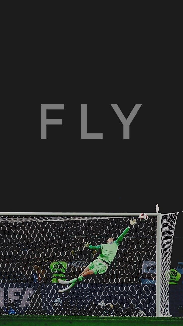 a soccer goalie is in mid air after hitting the ball