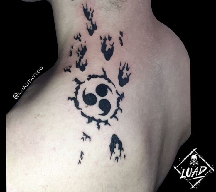 the back of a man's neck is covered in black ink and has claws coming out of it