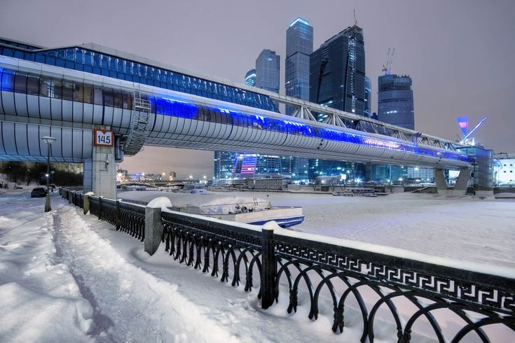 the city skyline is lit up in blue and white as it stands on snow covered ground