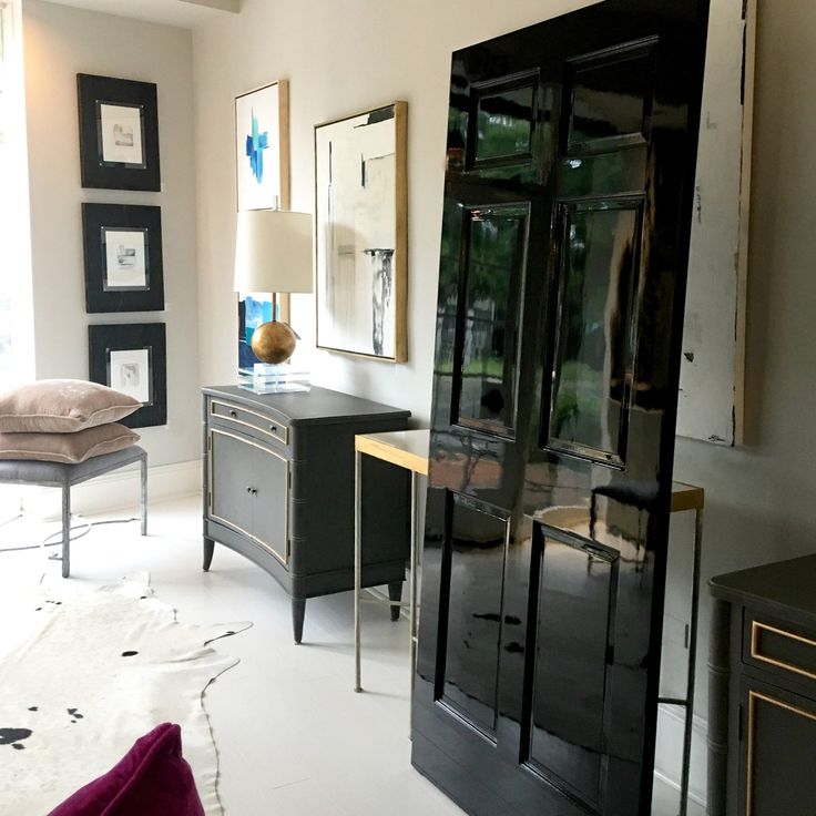 a living room filled with furniture next to a wall mounted cabinet and mirror on the wall