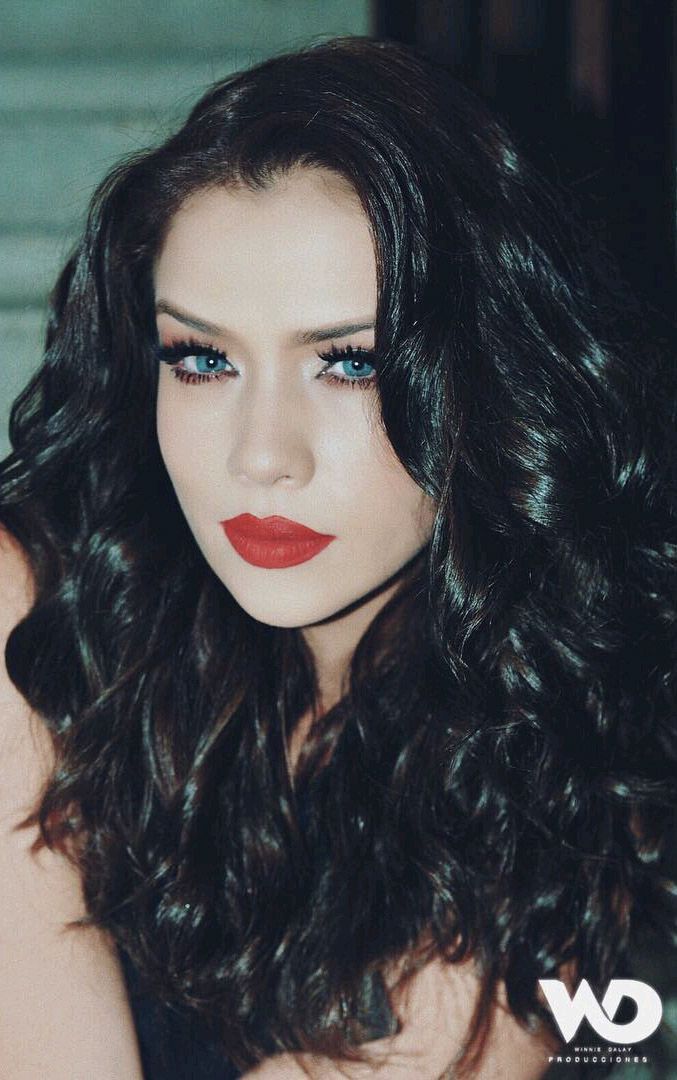 a woman with long dark hair and red lipstick