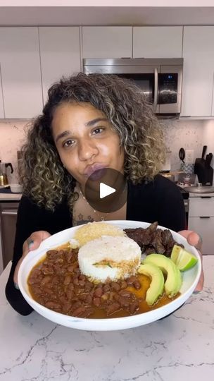 a woman is holding a bowl of food