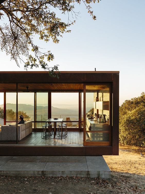 a modern house with glass walls on the outside and wood flooring in the inside