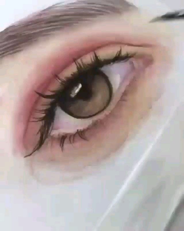 an eye with long lashes and brown eyes